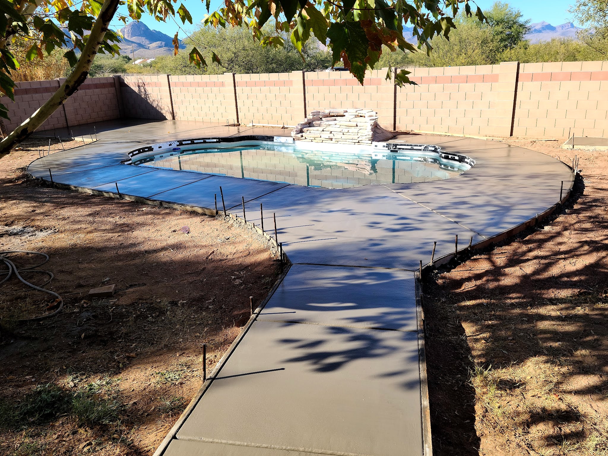 Curving concrete walkway around a backyard pool
