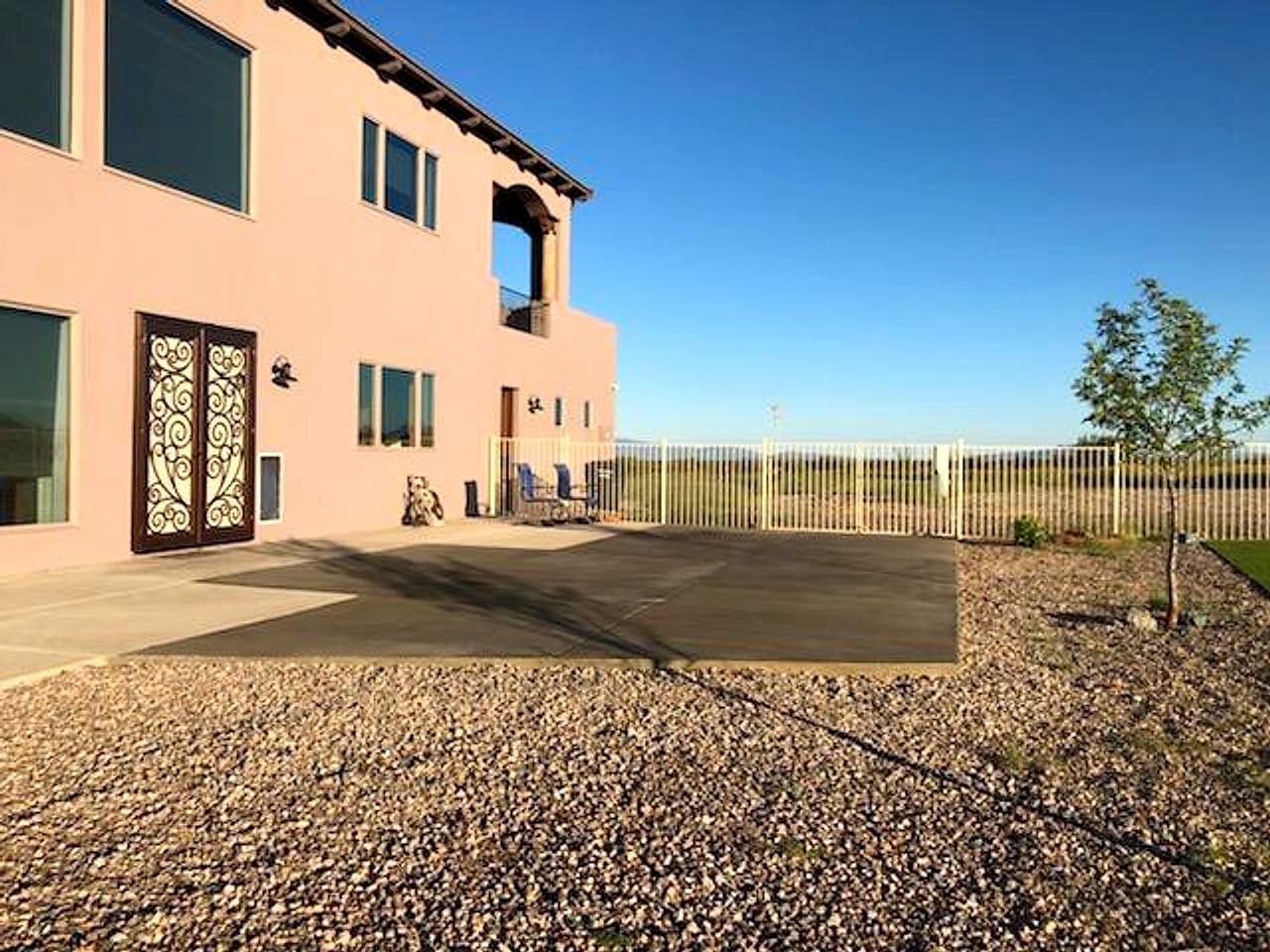 Back patio slab behind a two-story stucco house