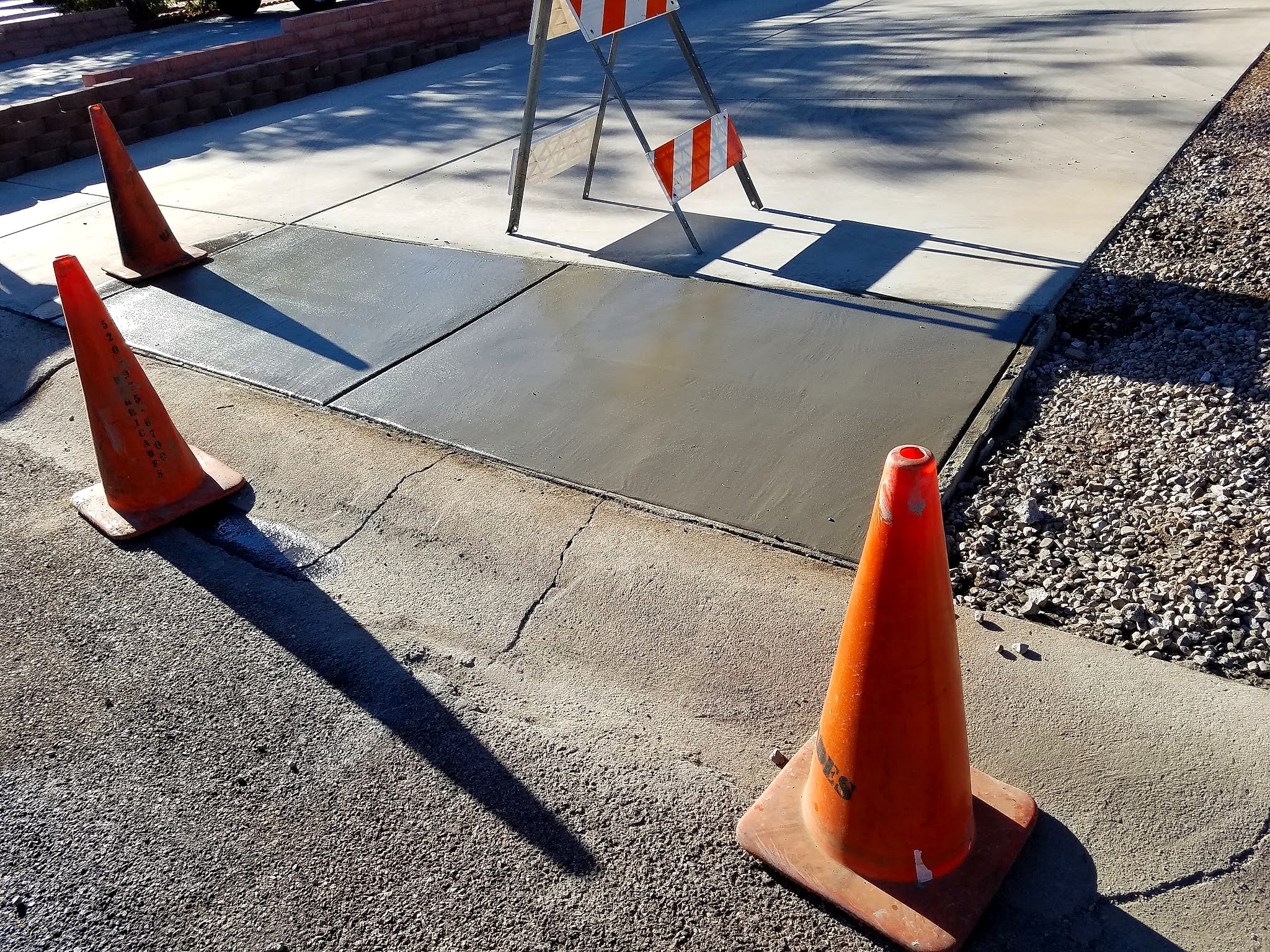 New sidewalk panels with safety cones around the fresh pour